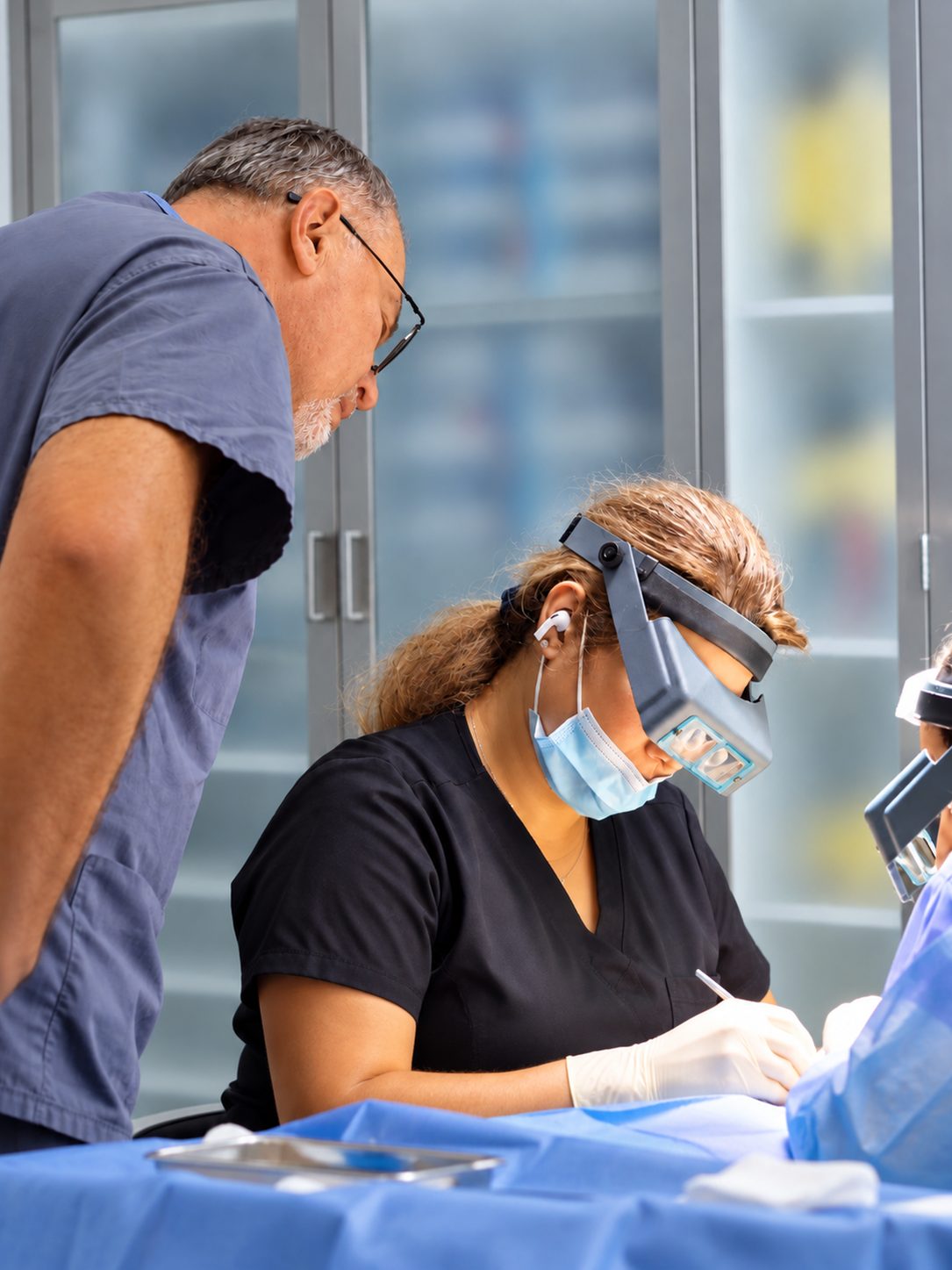 Technician working under magnifying loupes while Dr. Val Prokurat, MD reviews the procedure at Nova Medical NYC on the Upper East Side